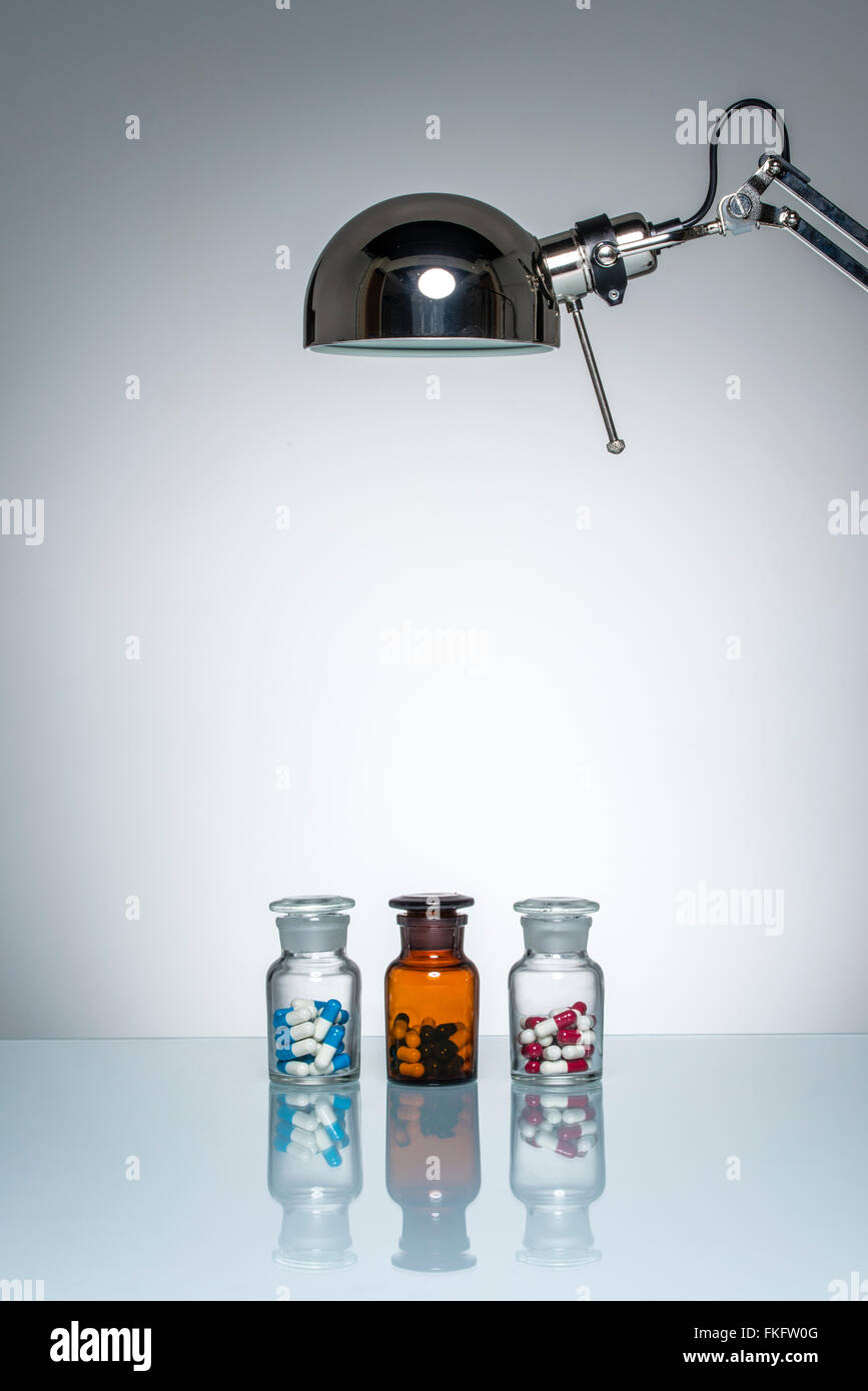 Illuminazione di bottiglia farmaci medicina pillola con una lampada da scrivania sul round illuminazione da studio Foto Stock