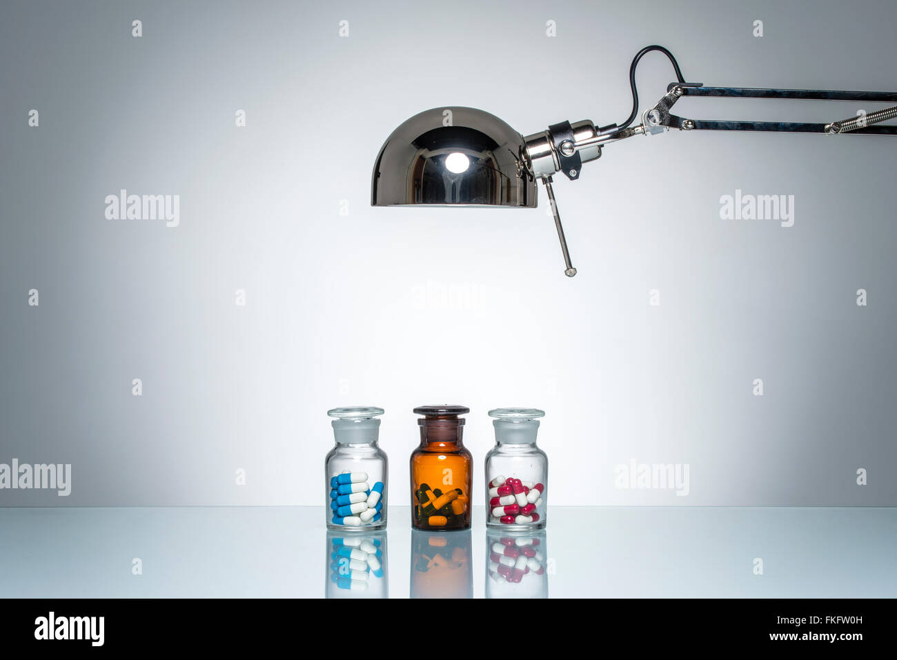 Illuminazione di bottiglia farmaci medicina pillola con una lampada da scrivania sul round illuminazione da studio Foto Stock