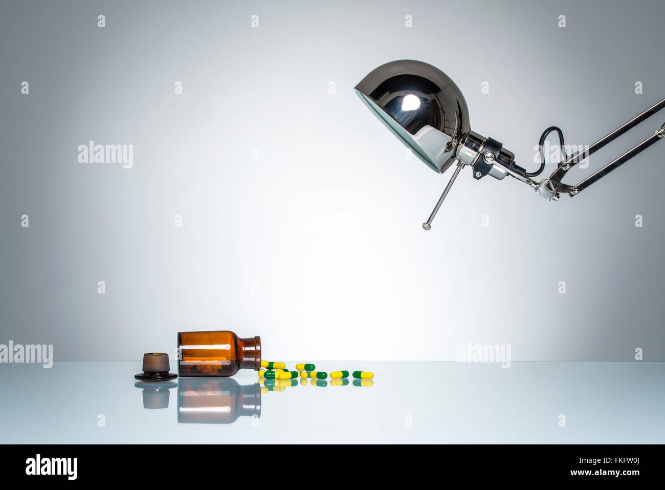 Illuminazione di bottiglia farmaci medicina pillola con una lampada da scrivania sul round illuminazione da studio Foto Stock