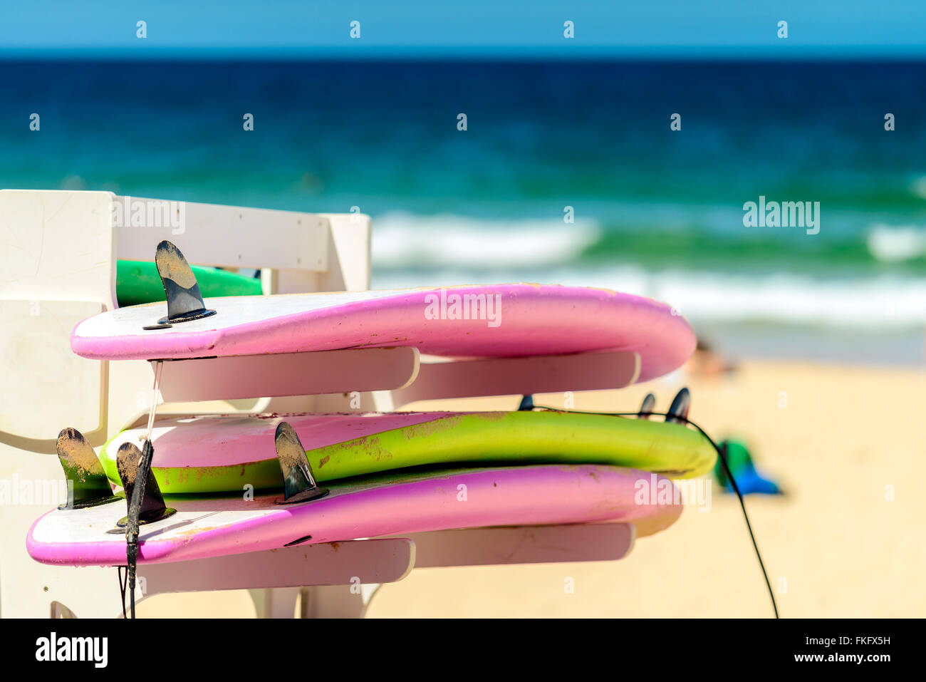 Schede di navigazione posto sulla cremagliera in una riga a Manly Beach, Australia Foto Stock