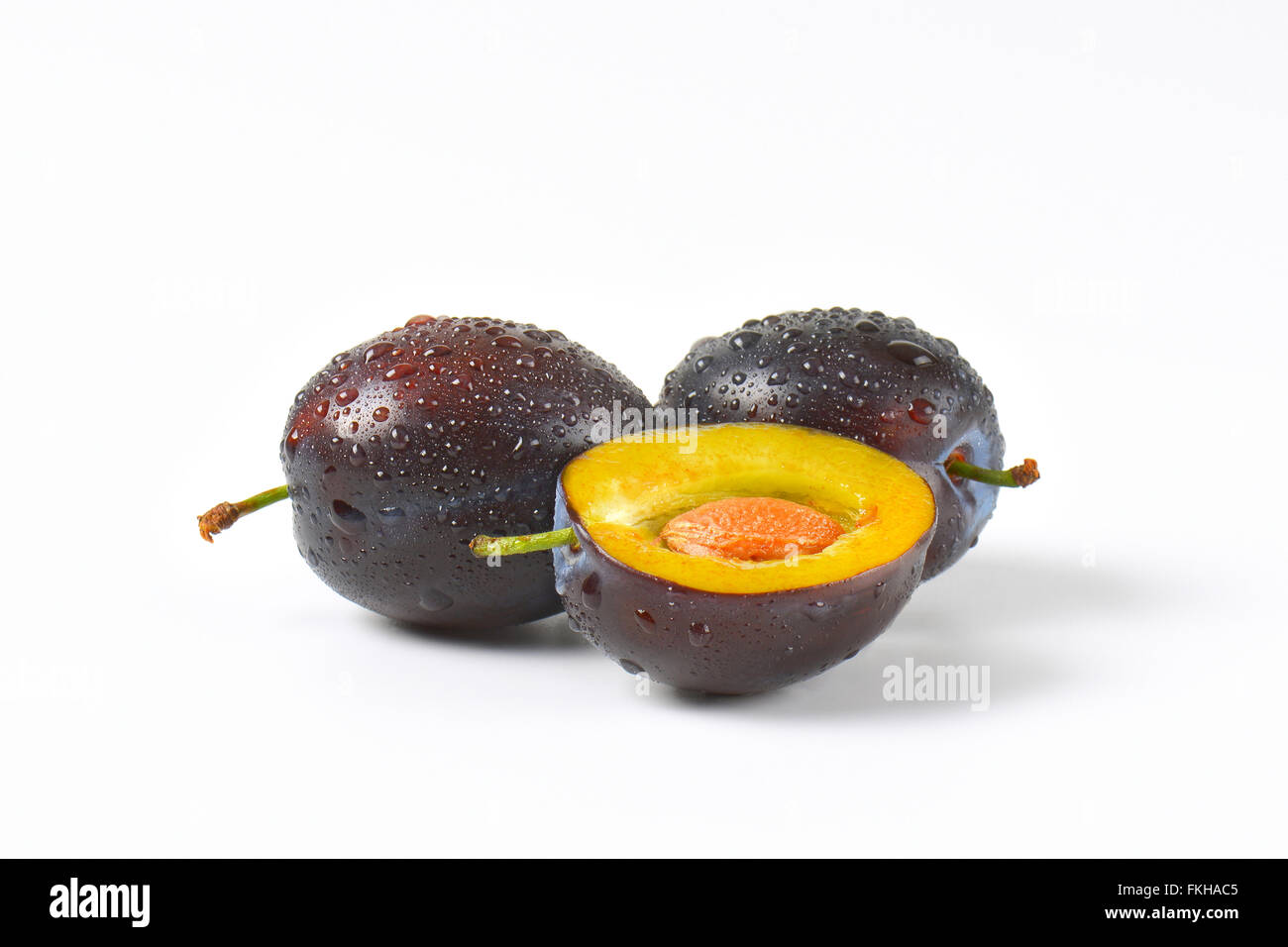 Due e Mezza lavato le prugne su sfondo bianco Foto Stock