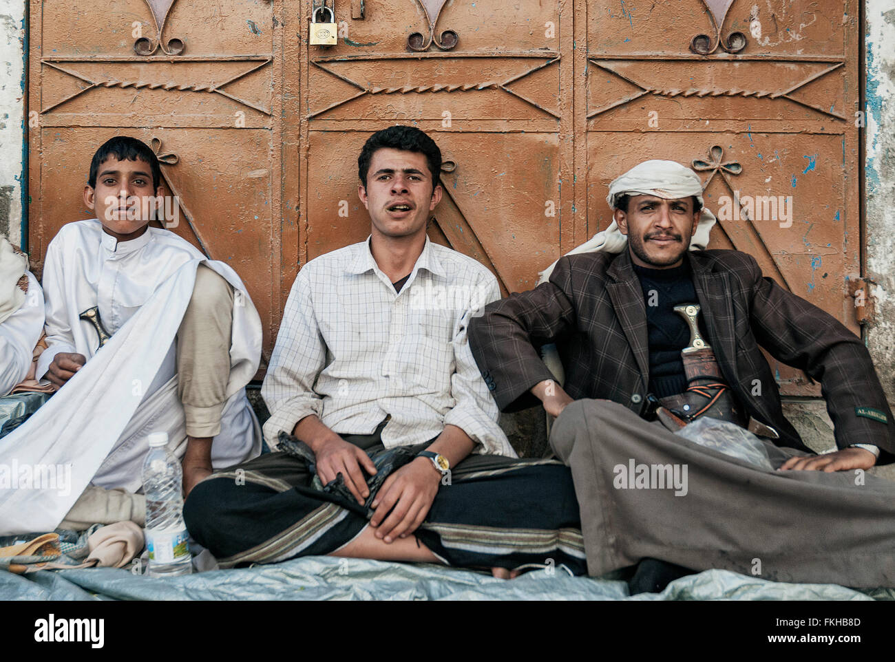 Giovani uomini arabi chewing khat qat stupefacente di foglie in sanaa yemen street Foto Stock