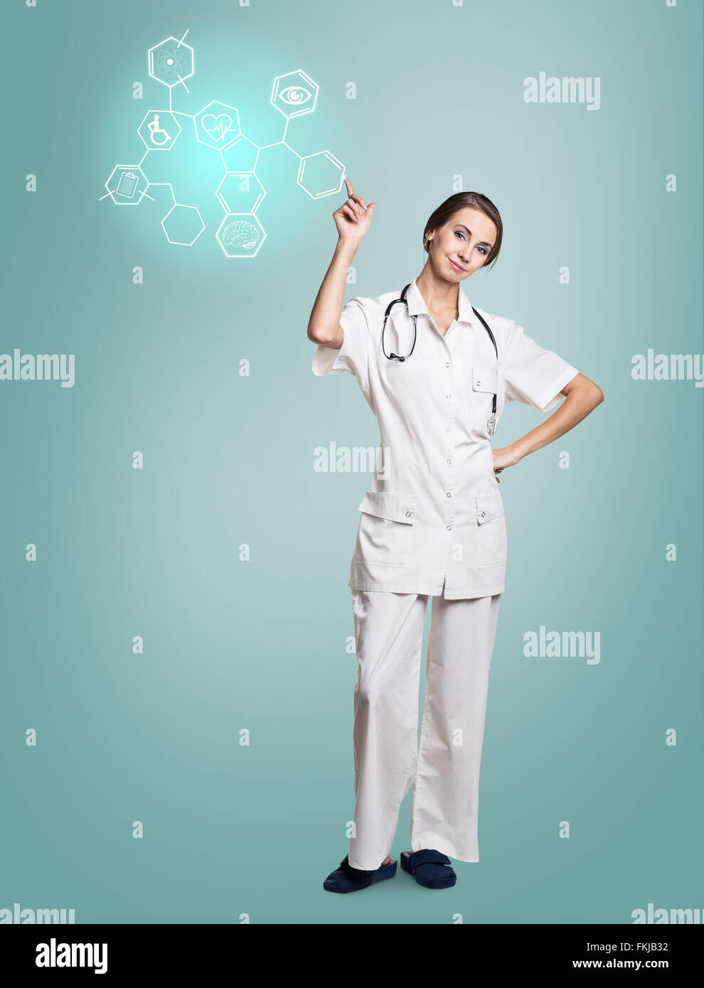 Medico donna in uniforme toccare esagono con icone Foto Stock
