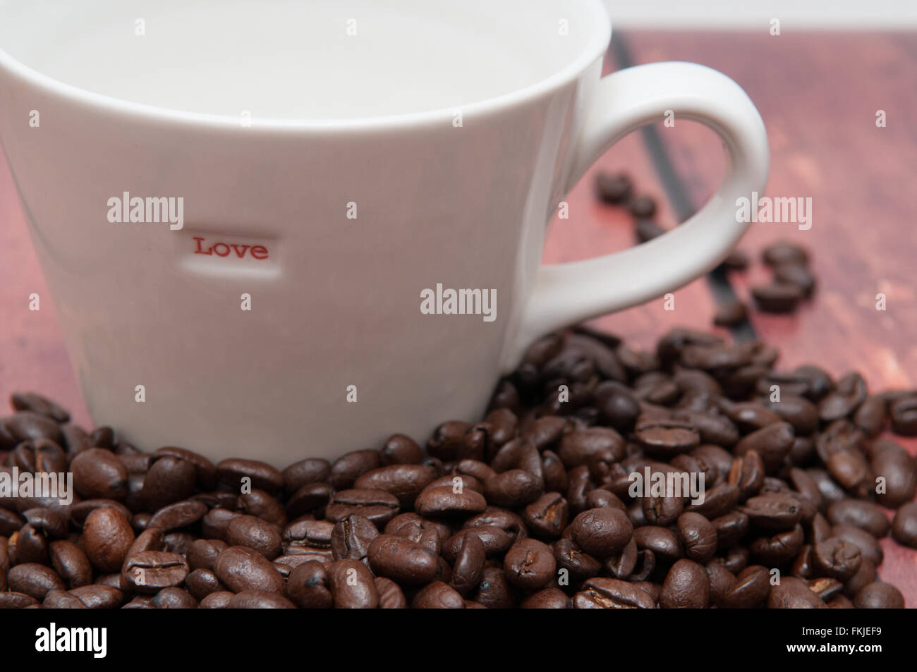 Di sapore molto forte i chicchi di caffè in una normale tazza bianca Foto Stock