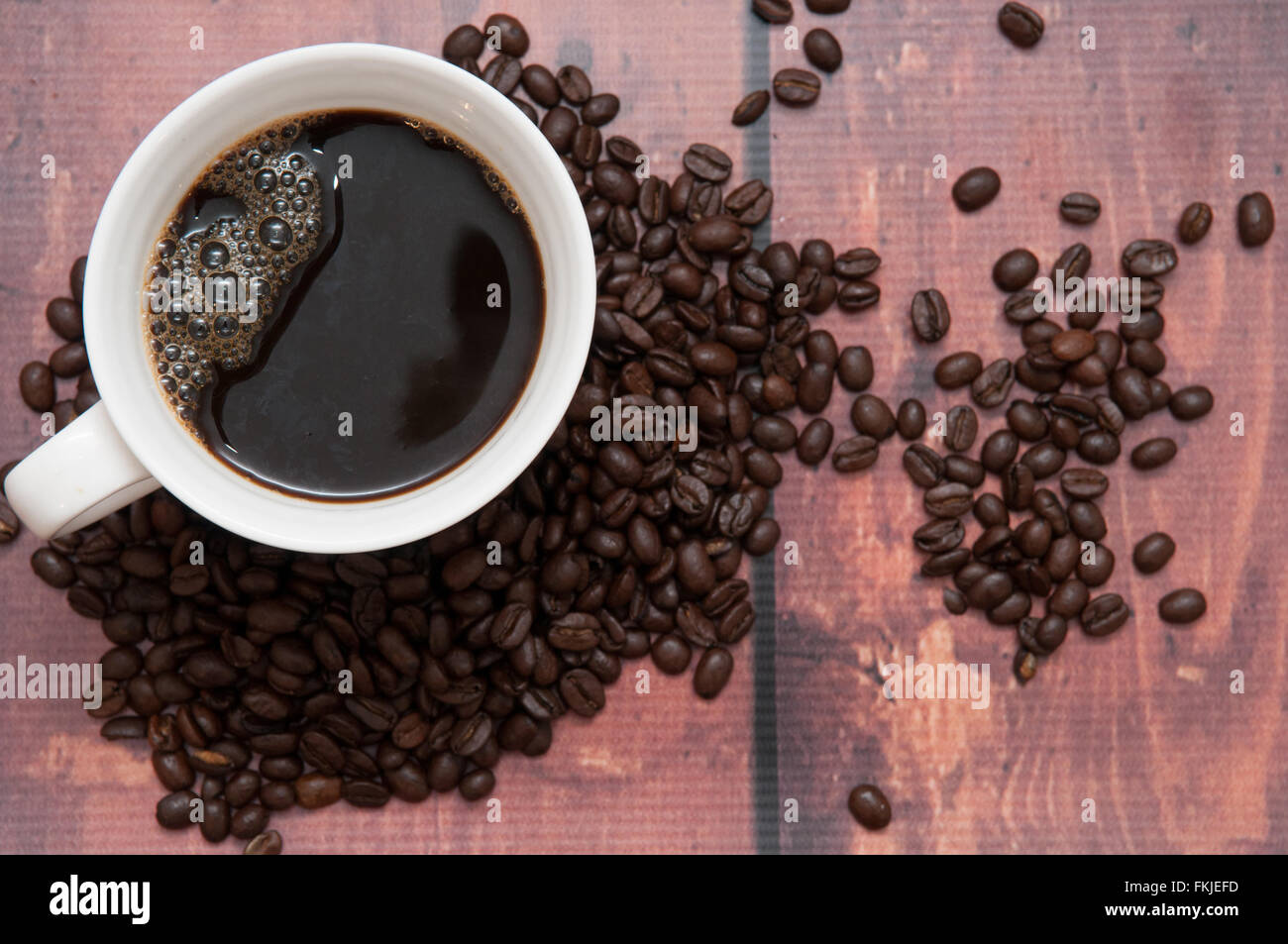 Di sapore molto forte i chicchi di caffè in una normale tazza bianca Foto Stock