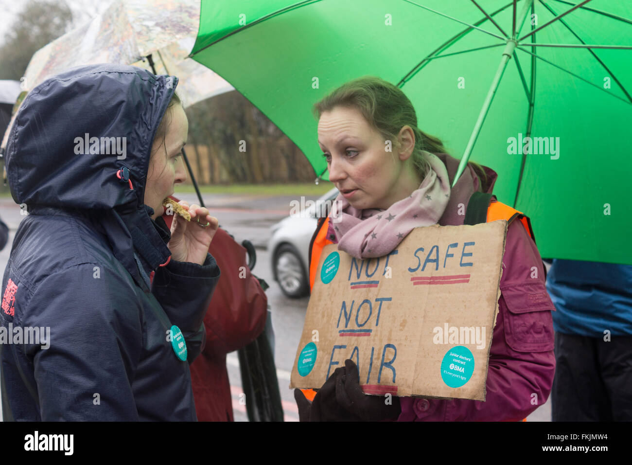 Oxford, Regno Unito, 9 marzo 2016 i medici junior formano una linea di picket nonostante le intemperie di questa mattina, durante l'inizio del primo sciopero medico nel Regno Unito per 40 anni. I medici fanno una vista colorata mentre si accoccolano sotto gli ombrelli. NELLA FOTO: Dr Rachel Clarke (lato) e collega. Credit: Bridget Catterall/Alamy Live News Foto Stock