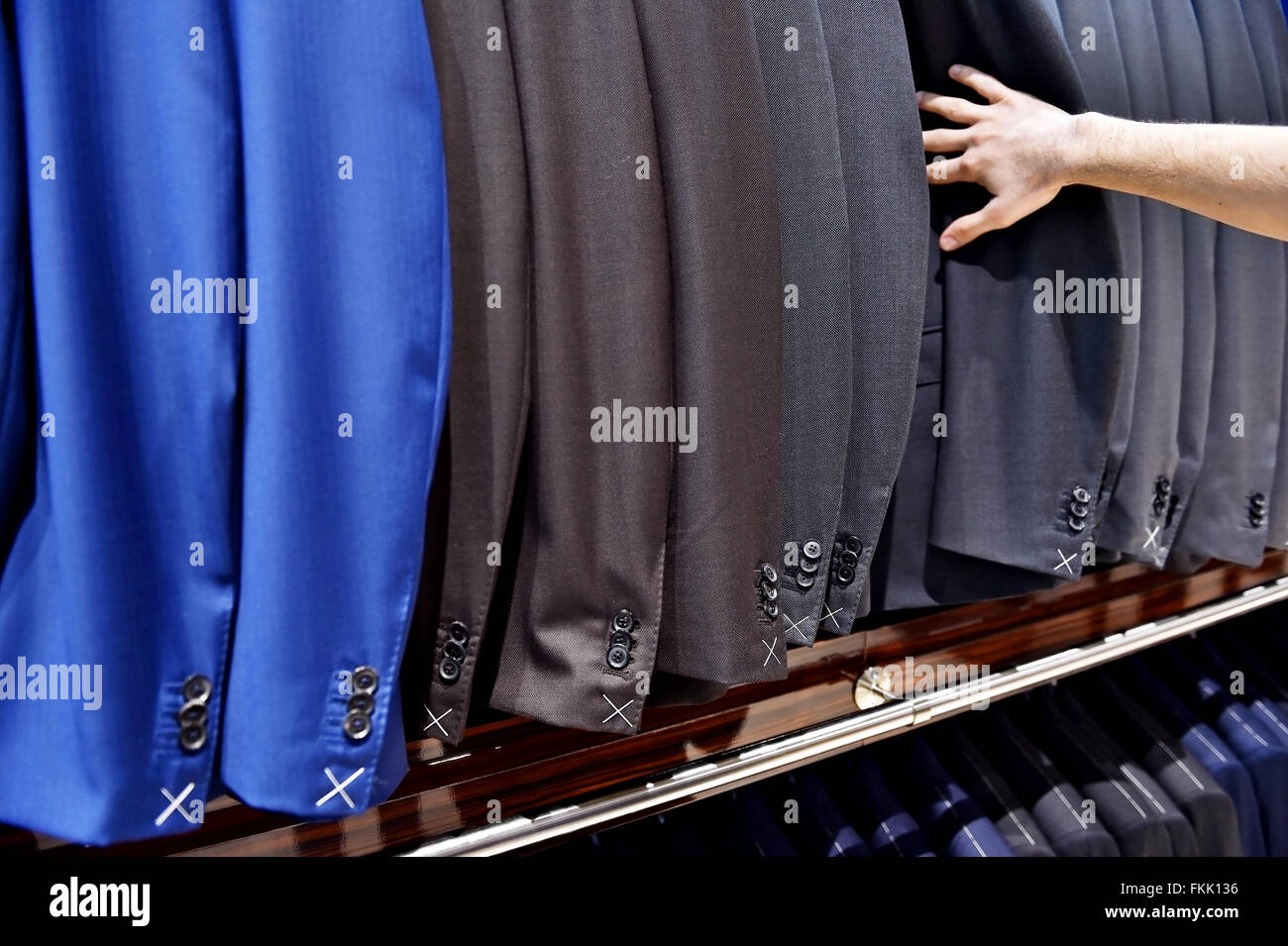 Dettaglio shot con raccolta a mano out man suit jacket in una tuta shop Foto Stock