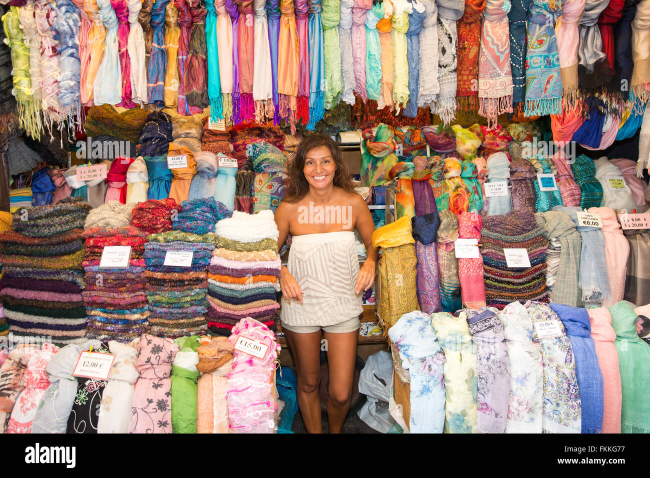 Donna vendita sciarpe e tessuto dal suo vicino di stallo occupato il  mercato centrale di Firenze, Italia. Sorridente e guardando la fotocamera  Foto stock - Alamy