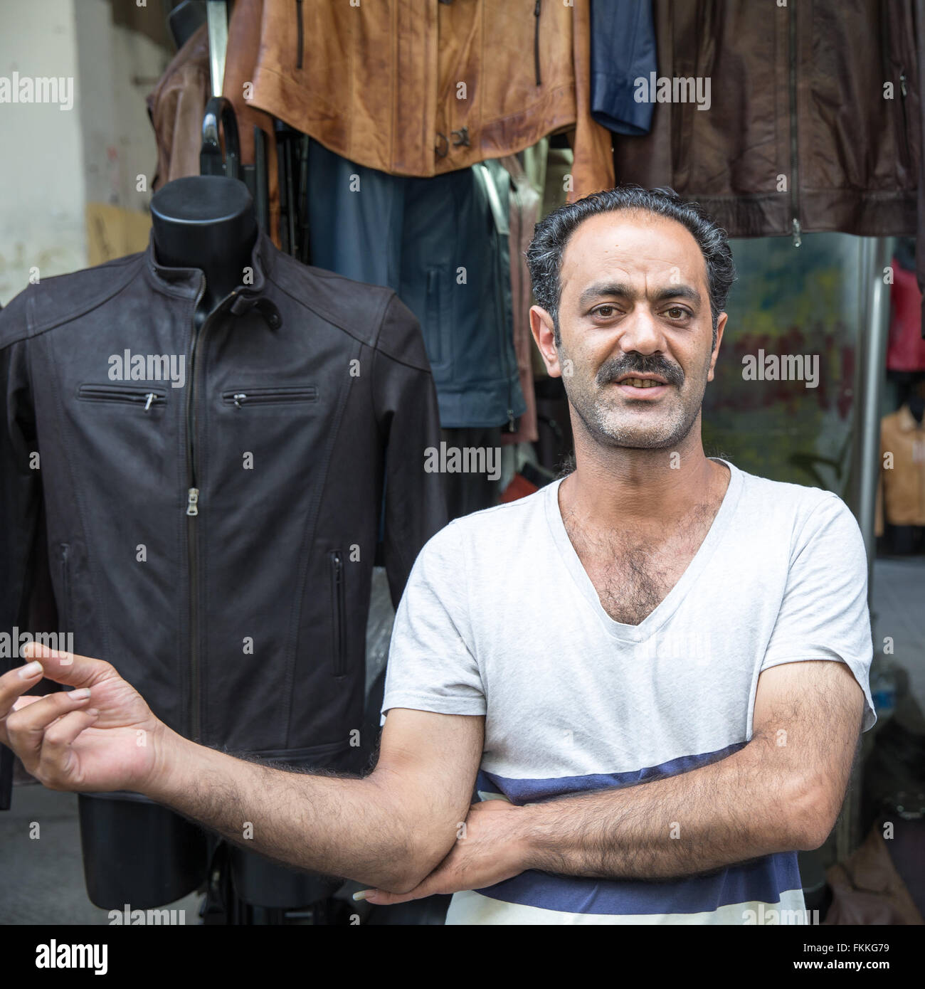 Pelle italiana venditore in piedi nella parte anteriore della sua stalla vicino alla trafficata mercato centrale di Firenze, Italia. Guardando alla fotocamera. Foto Stock