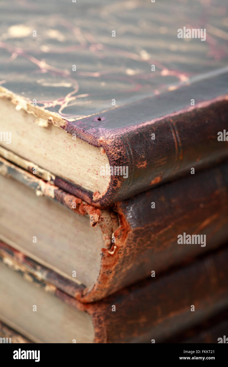 Extreme closeup della pila di alcuni molto vecchi libri come sfondo Foto Stock