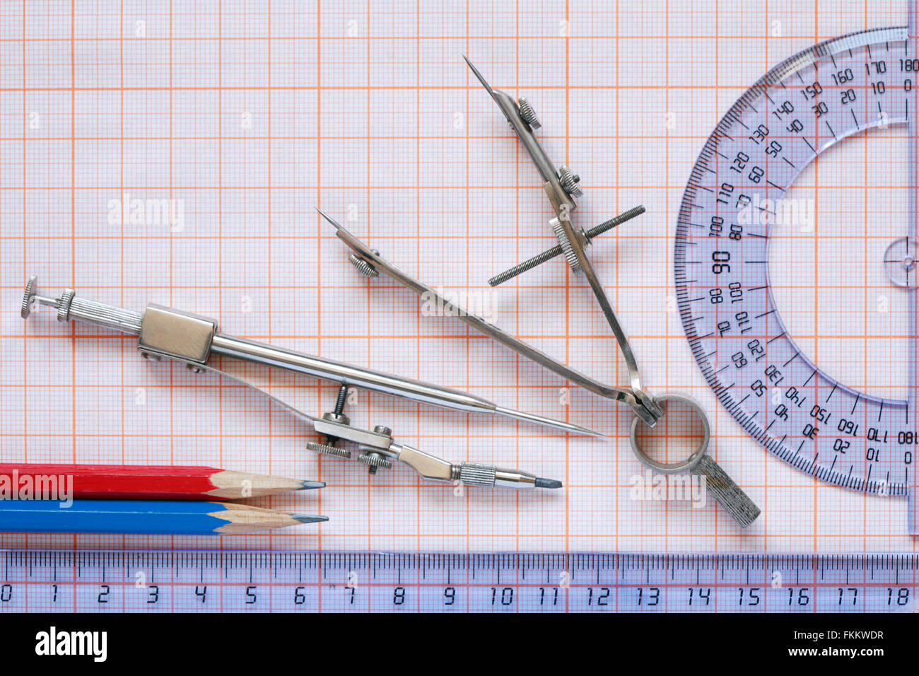Set di strumenti di disegno e righelli su un foglio di carta millimetrata Foto Stock