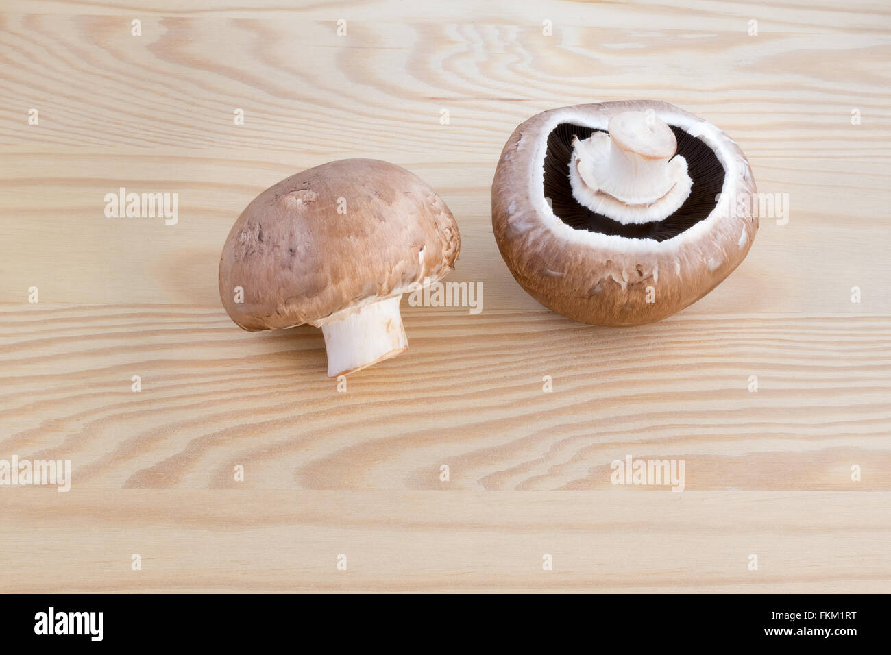 Due funghi castagne su di un tagliere di legno Foto Stock