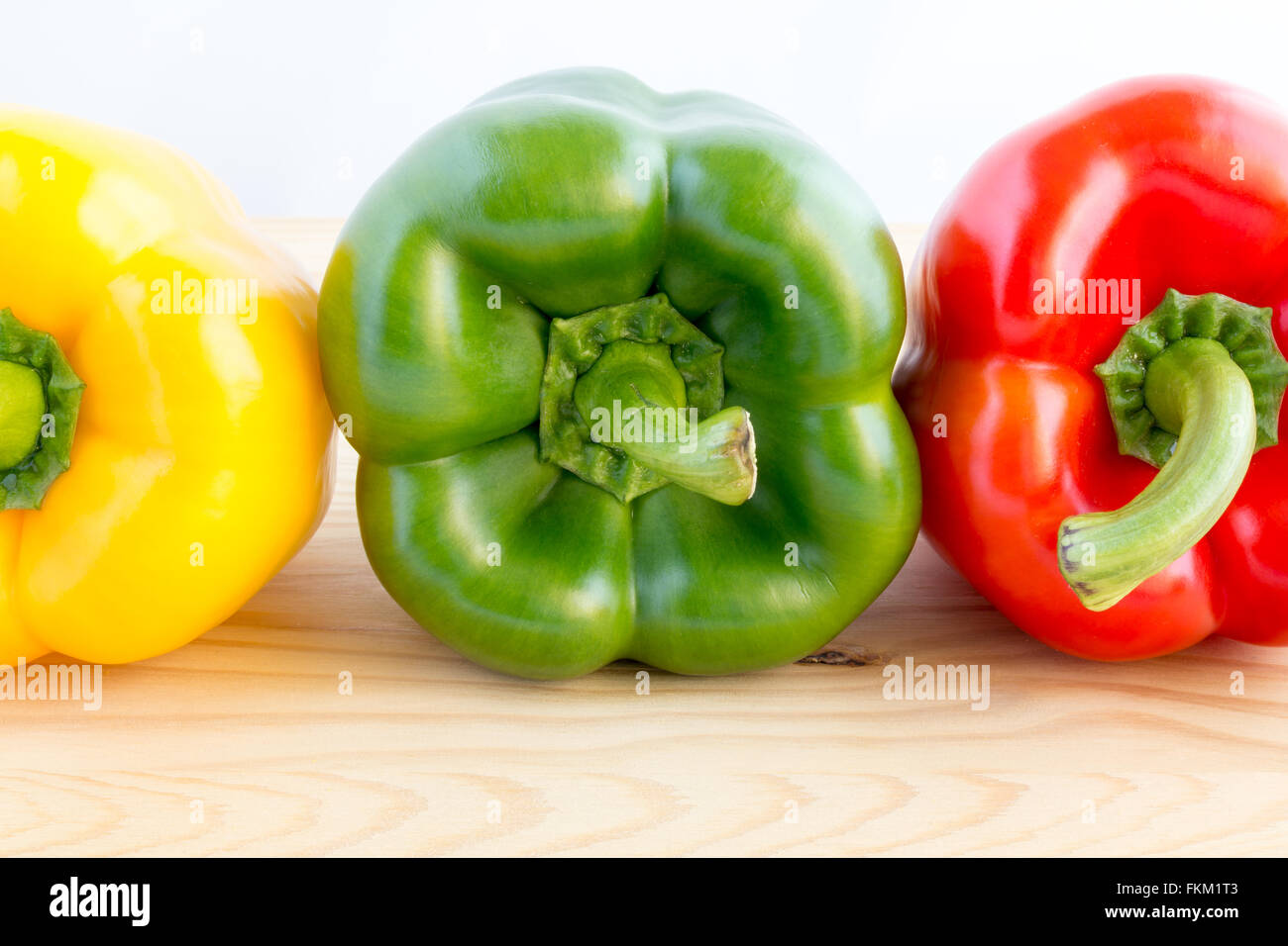Tre i peperoni in una fila in diversi colori, giallo, verde e rosso Foto Stock