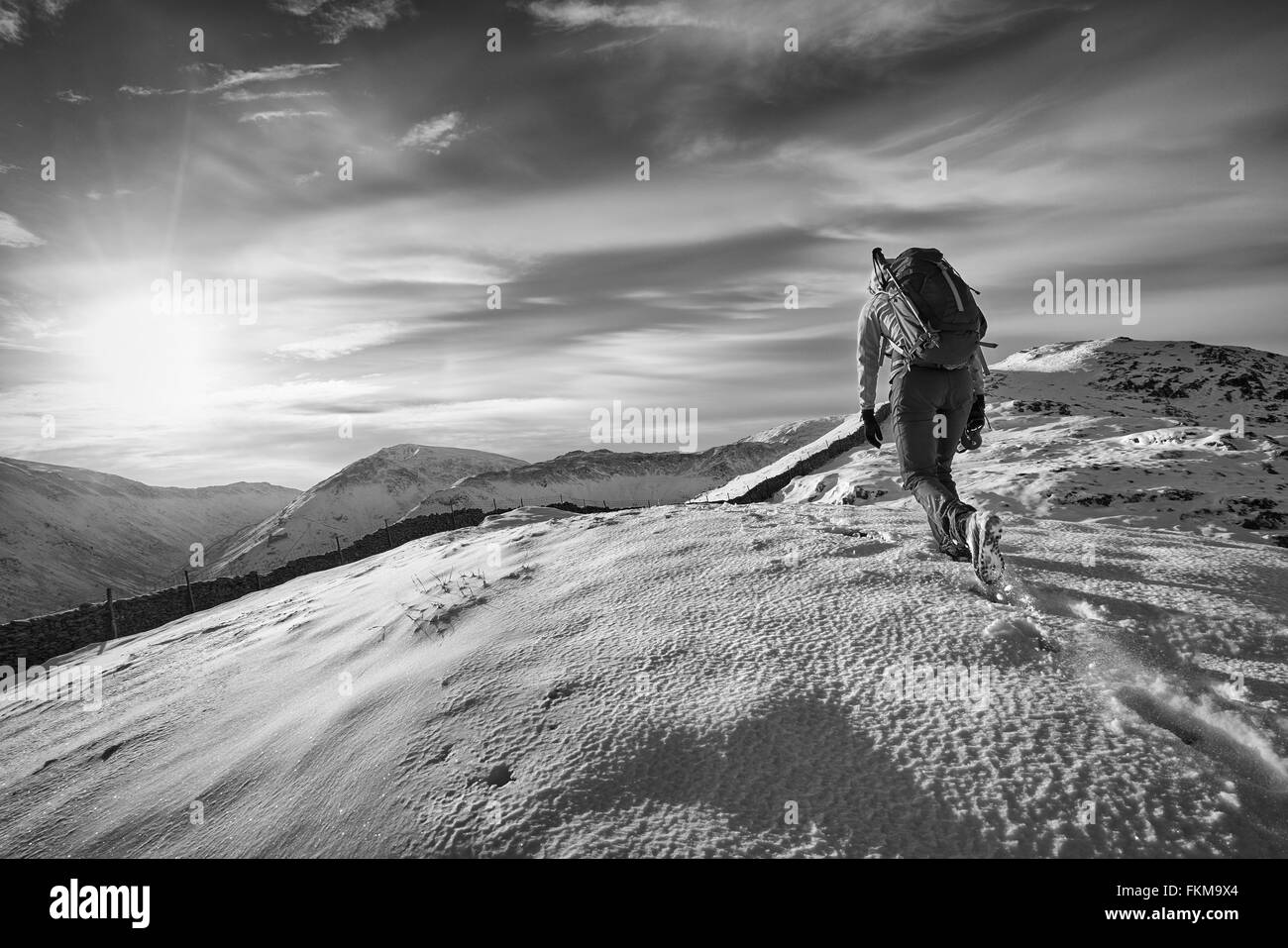 Escursionista camminare su montagne coperte di neve nel Regno Unito. Il grano e il colore applicato per lo styling Foto Stock