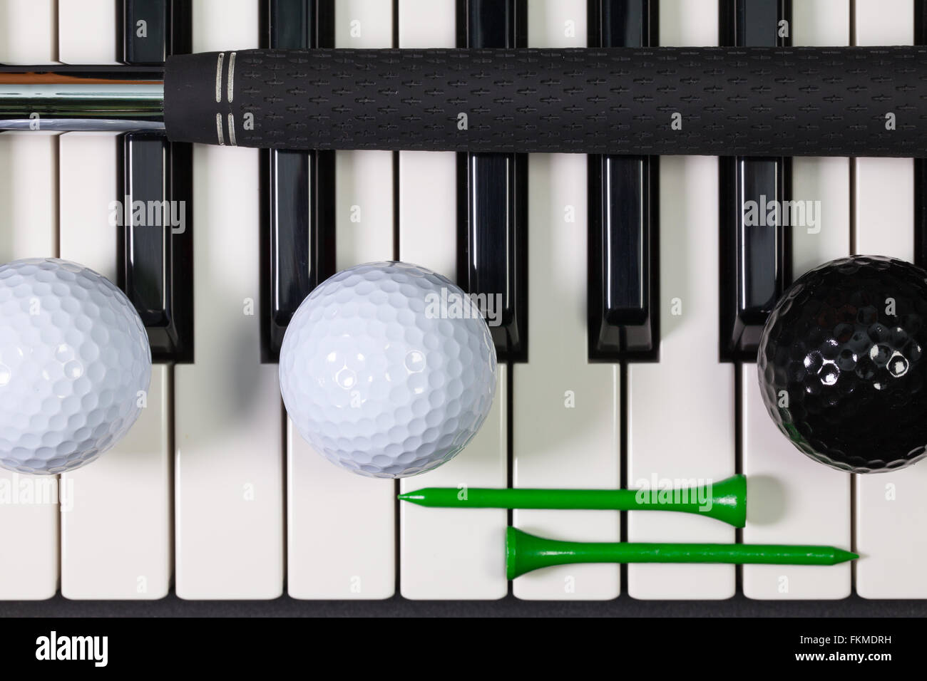 Virtuosi di gioco - Una tastiera di pianoforte e diverse attrezzature da golf Foto Stock