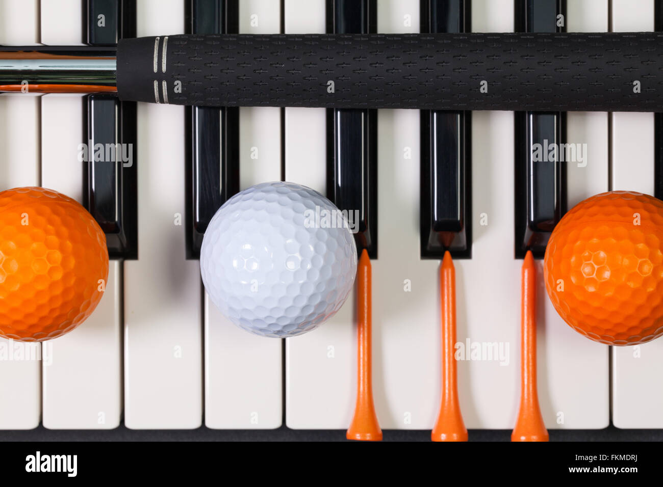 Virtuosi di gioco - Una tastiera di pianoforte e diverse attrezzature da golf Foto Stock