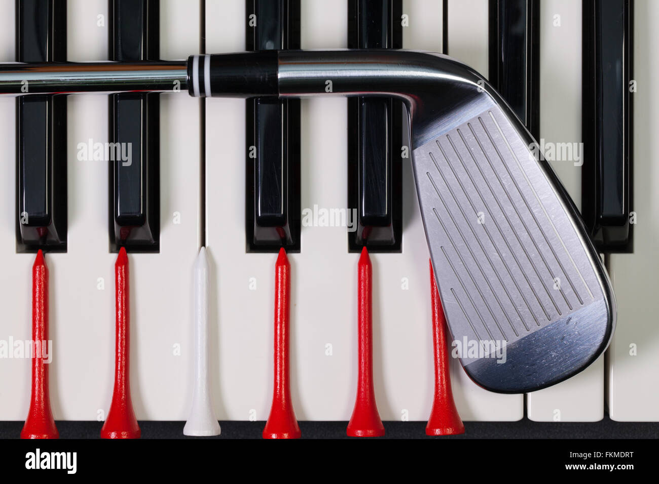 Virtuosi di gioco - Una tastiera di pianoforte e diverse attrezzature da golf Foto Stock