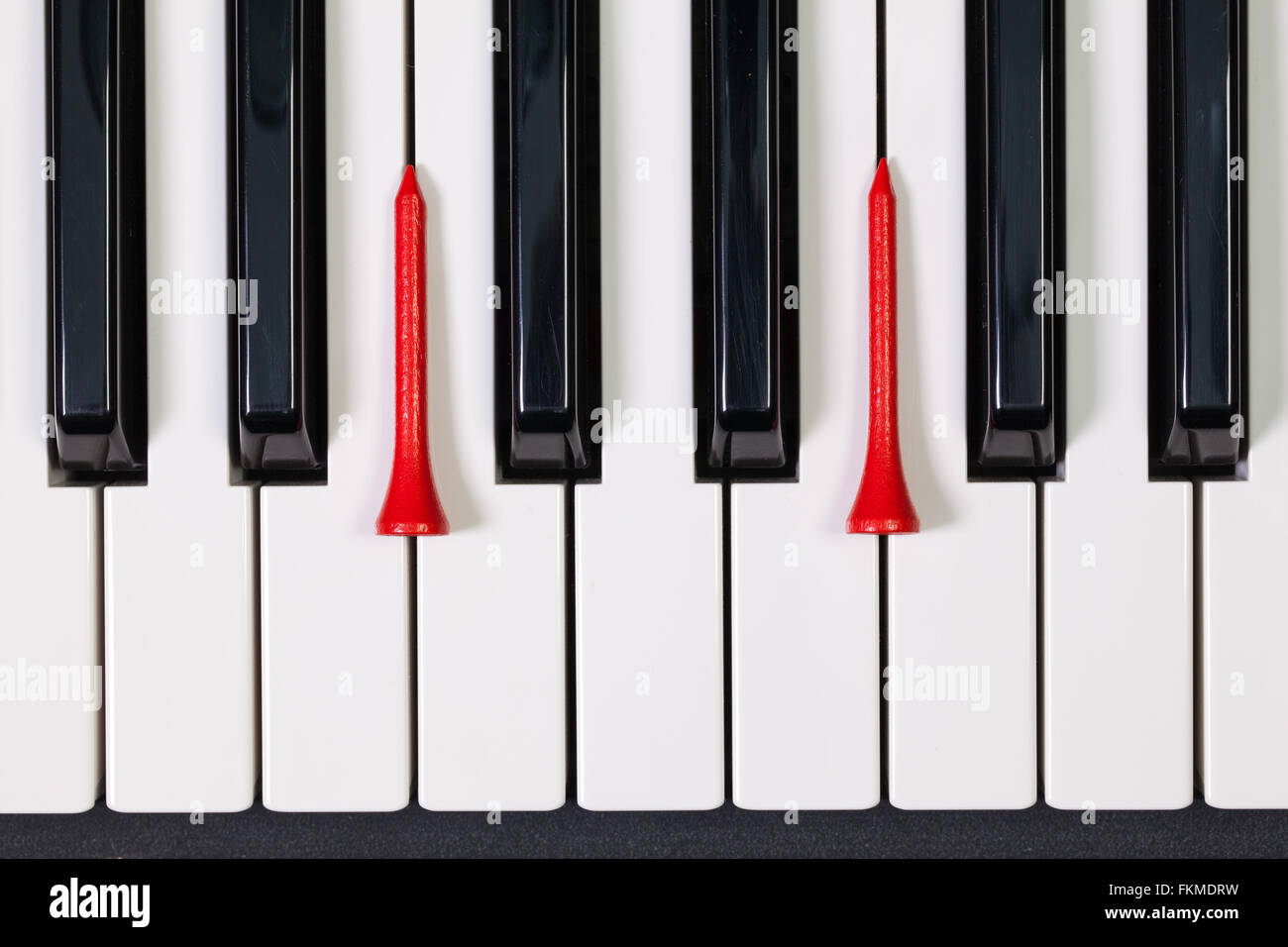 Virtuosi di gioco - Una tastiera di pianoforte e differenti palline da golf e tee di legno Foto Stock