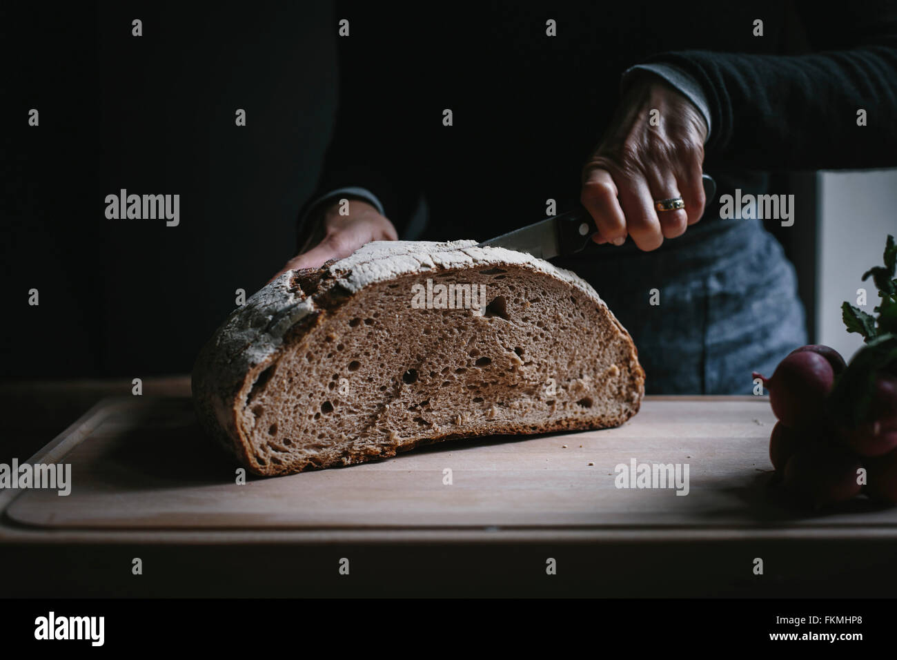 Mani tutta per affettare il pane di frumento con Coltello per pane Foto  stock - Alamy