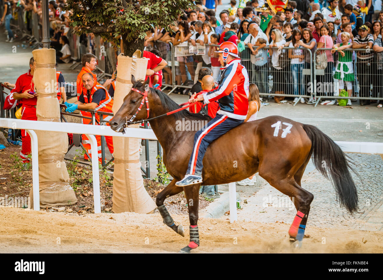 Asti, Italia - 15 Settembre 2012: cavalli correre sul rettilineo sotto le gabbie degli spettatori in Palio di Asti in Piemonte, Foto Stock
