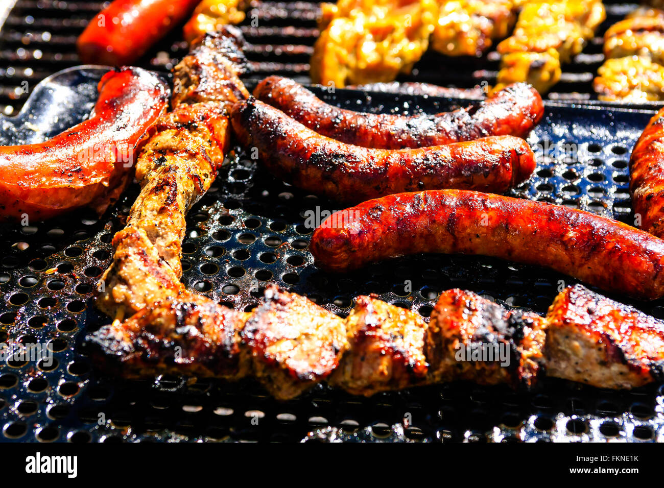 In prossimità di una griglia per il barbecue con il Bratwurst, pollo e pesce Foto Stock
