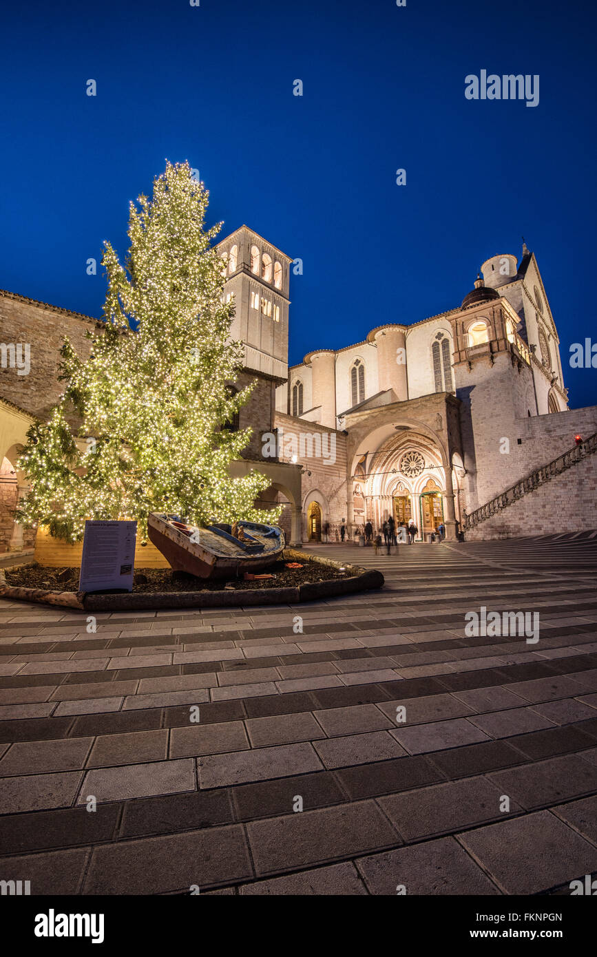 Ad Assisi, Umbria, Italia. Chiesa di San Francesco. Il grande albero di Natale e il presepe speciale scena su una barca di rifugiato Foto Stock