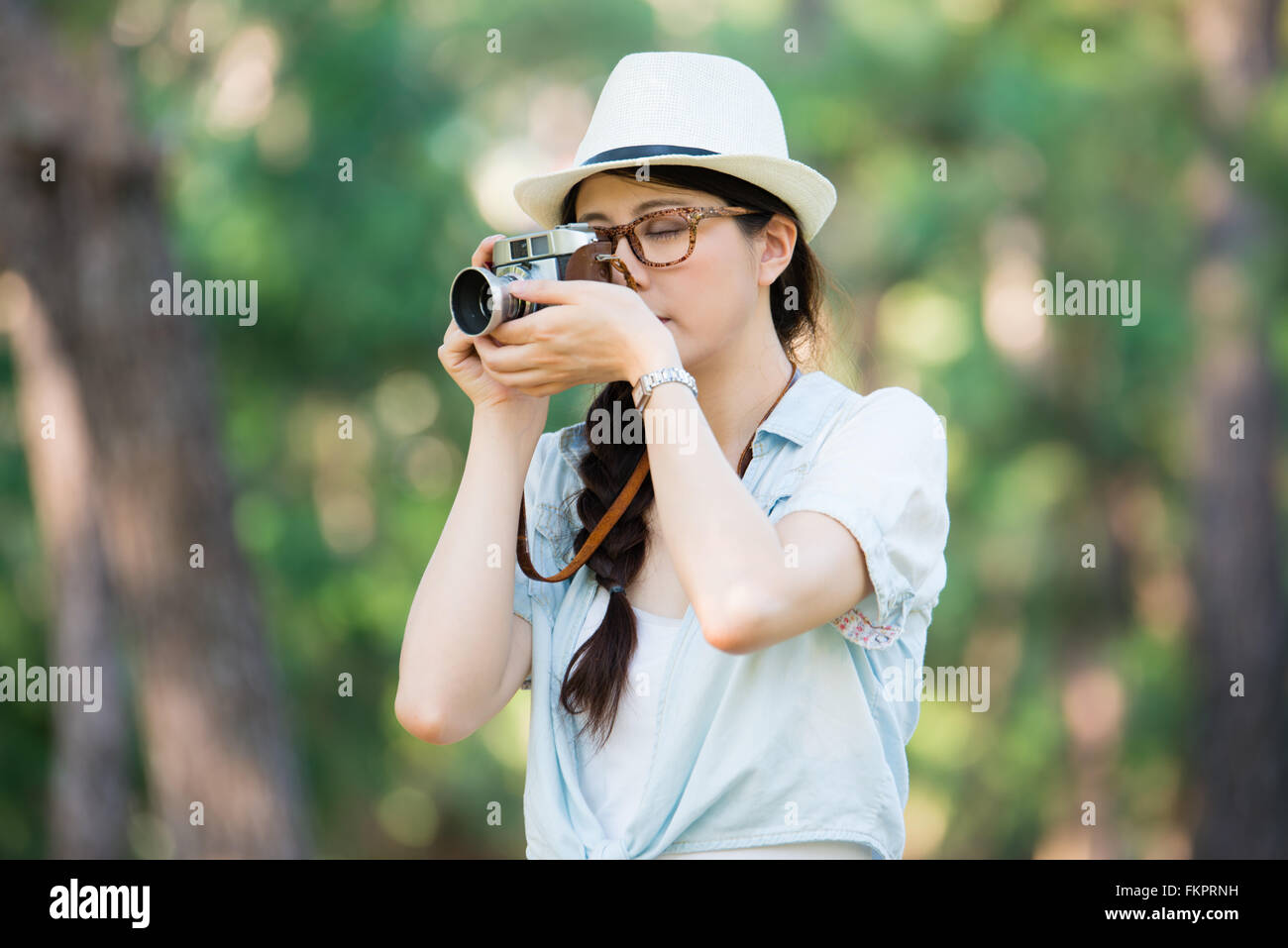 Giovane e bella ragazza con fotocamera retrò, corsa all'aperto Foto Stock