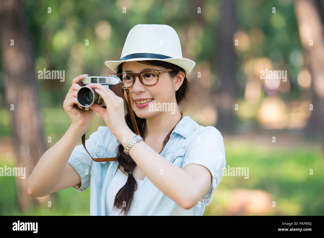 Giovane e bella ragazza sorriso con fotocamera retrò, corsa all'aperto Foto Stock