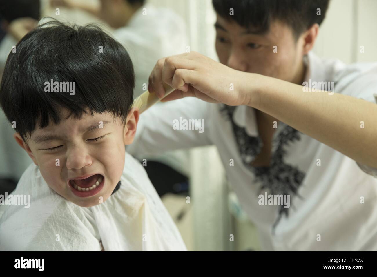 Huludao, cinese della provincia di Liaoning. Decimo Mar, 2016. Un bambino  piange come un barbiere gli dà un taglio di capelli a un barbiere presso il  Festival Longtaitou in Huludao, a nord-est