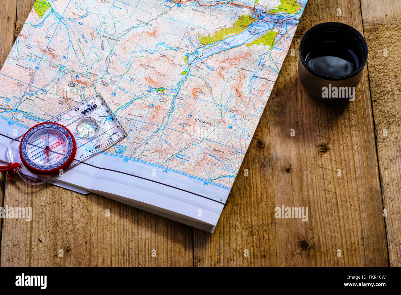 Controllo di percorso su una mappa con un drink. Foto Stock