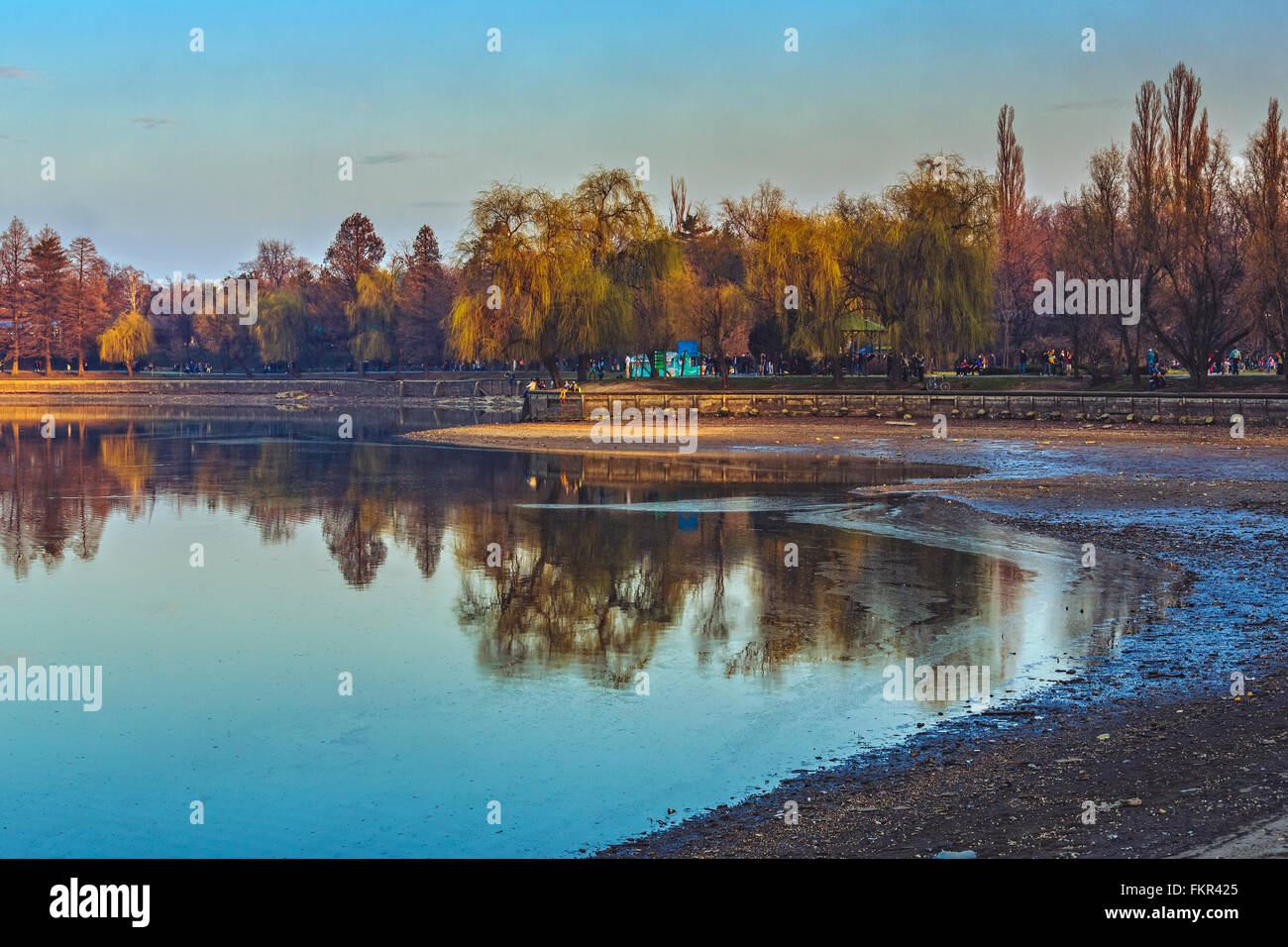 Bucarest, Romania - Marzo 09, 2013: serata tranquilla scena con le persone che si godono una passeggiata sulle rive del lago Herastrau svuotare Foto Stock