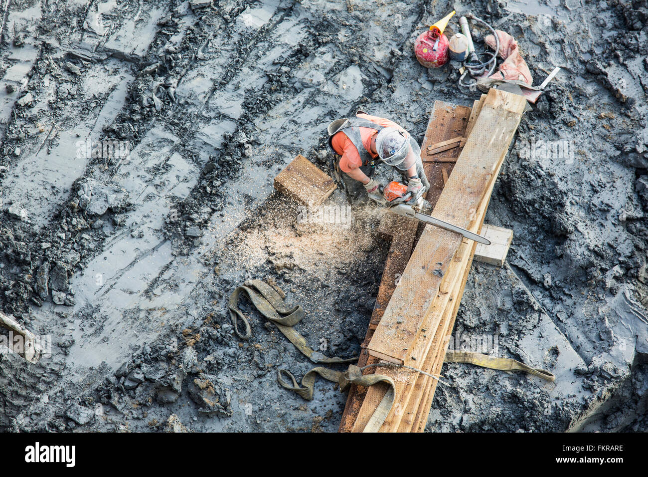 Lavoratore caucasica segatura di legno al sito in costruzione Foto Stock