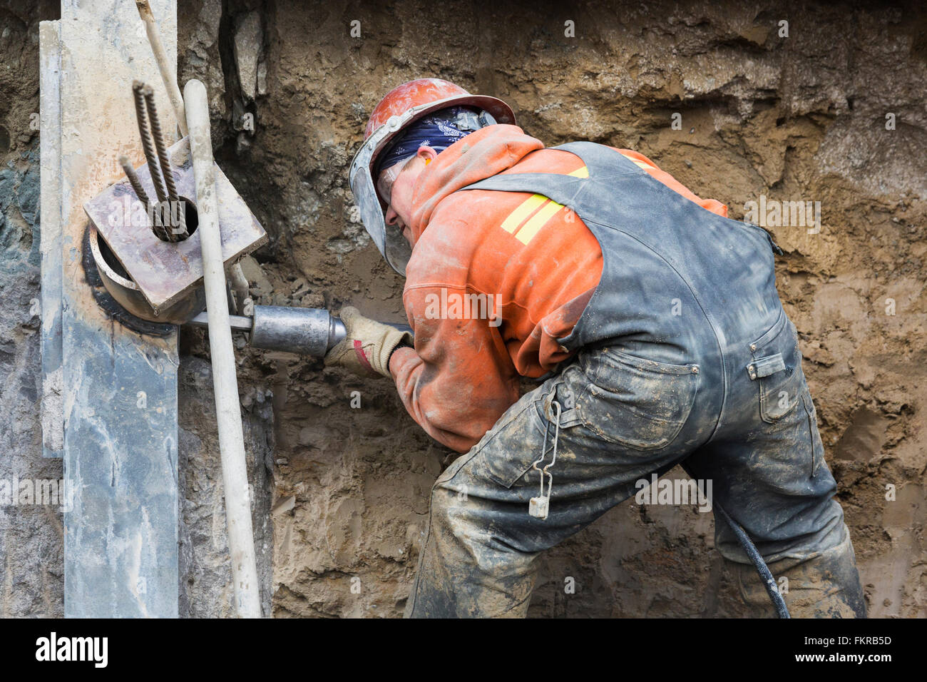 Lavoratore caucasica la perforazione a sito in costruzione Foto Stock