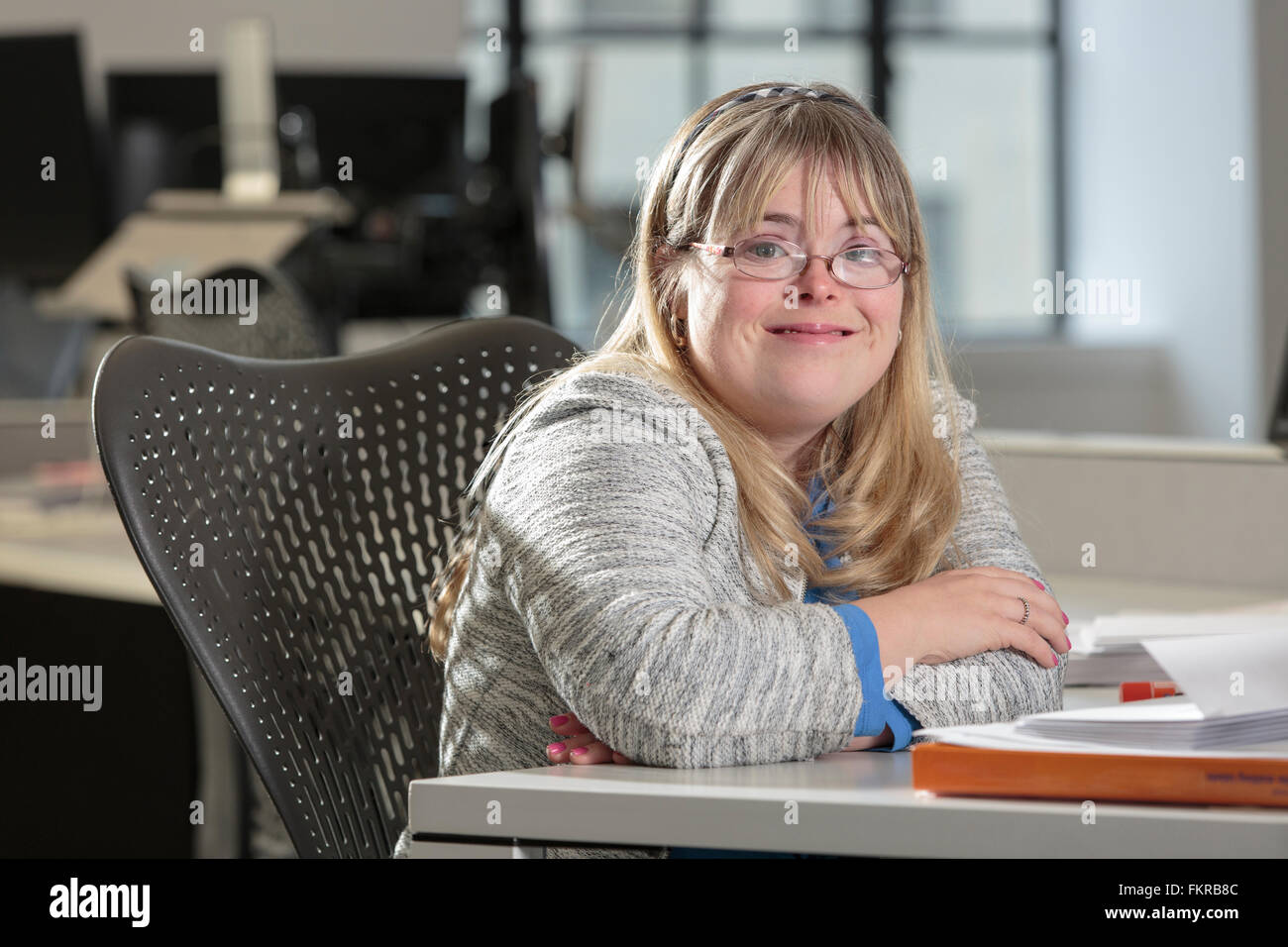 Imprenditrice caucasici con la sindrome di Down sorridente in ufficio Foto Stock