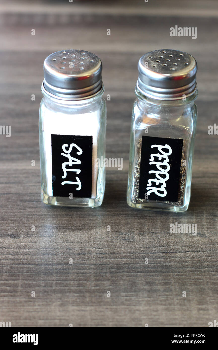 Sale e pepe su una tavola di legno Foto Stock