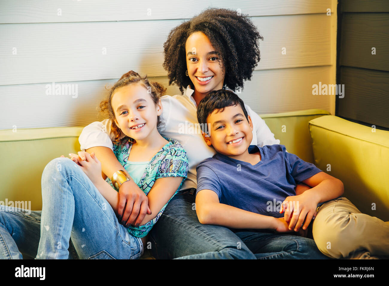 Madre e bambini relax su divano Foto Stock