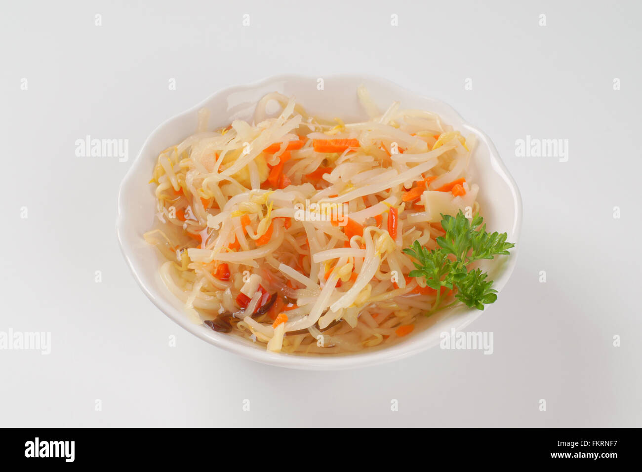 Ciotola di carota e di germogli di soia insalata su sfondo bianco Foto Stock