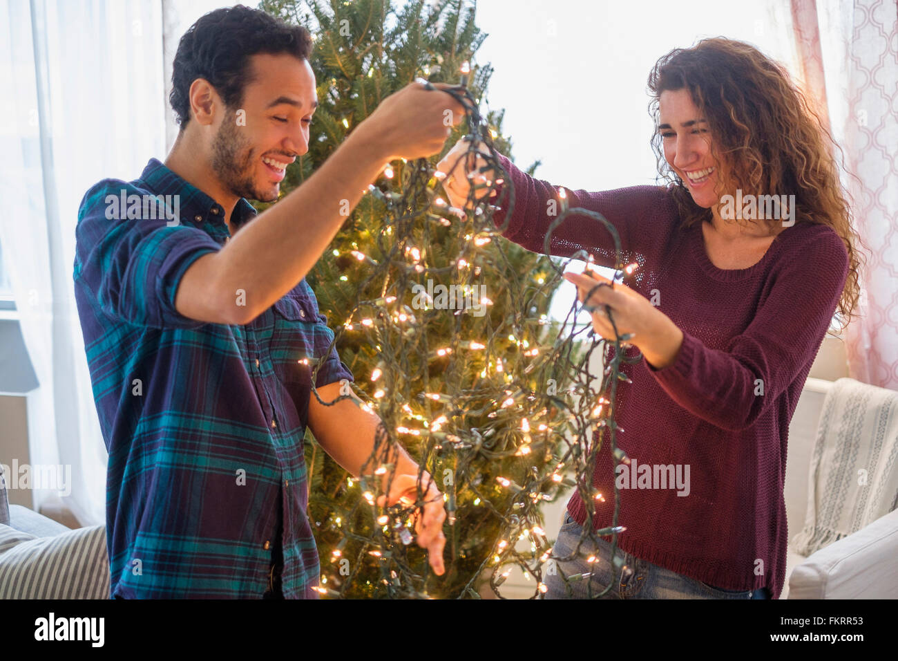 Giovane decorare albero di Natale Foto Stock