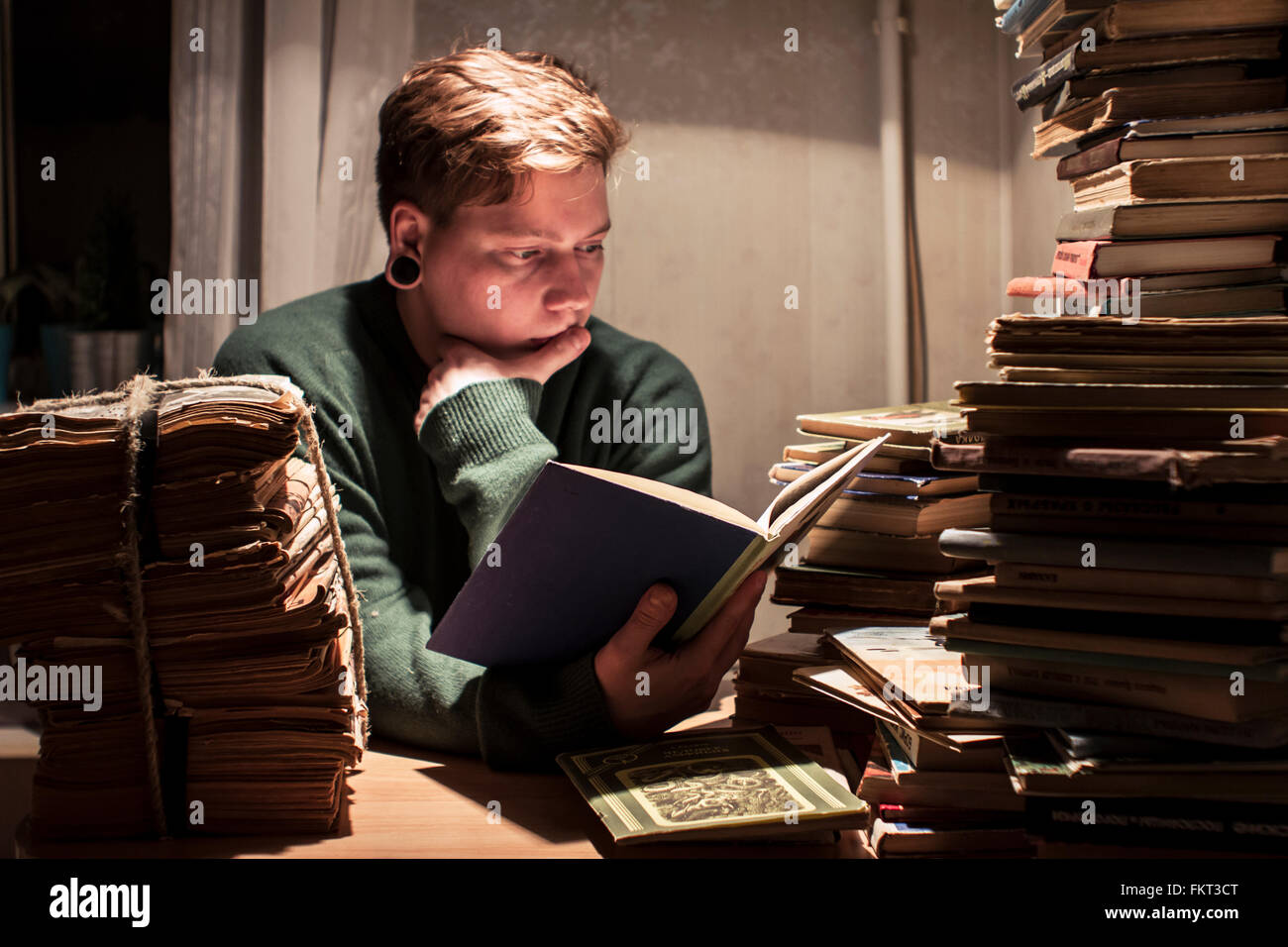 Uomo caucasico pila di lettura di libri Foto Stock