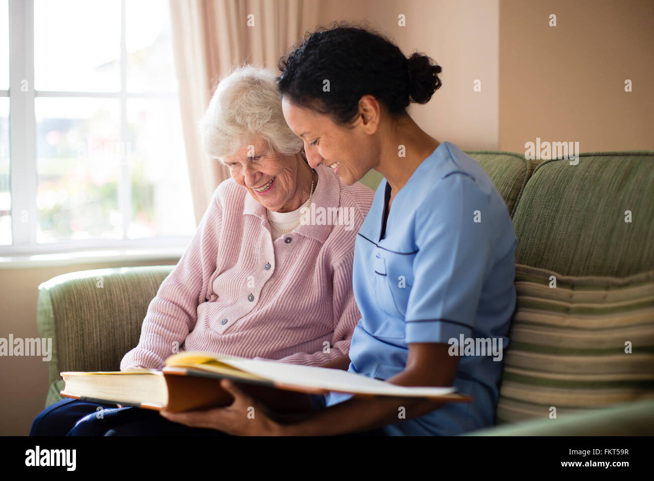 Infermiere e paziente guardando album di foto Foto Stock