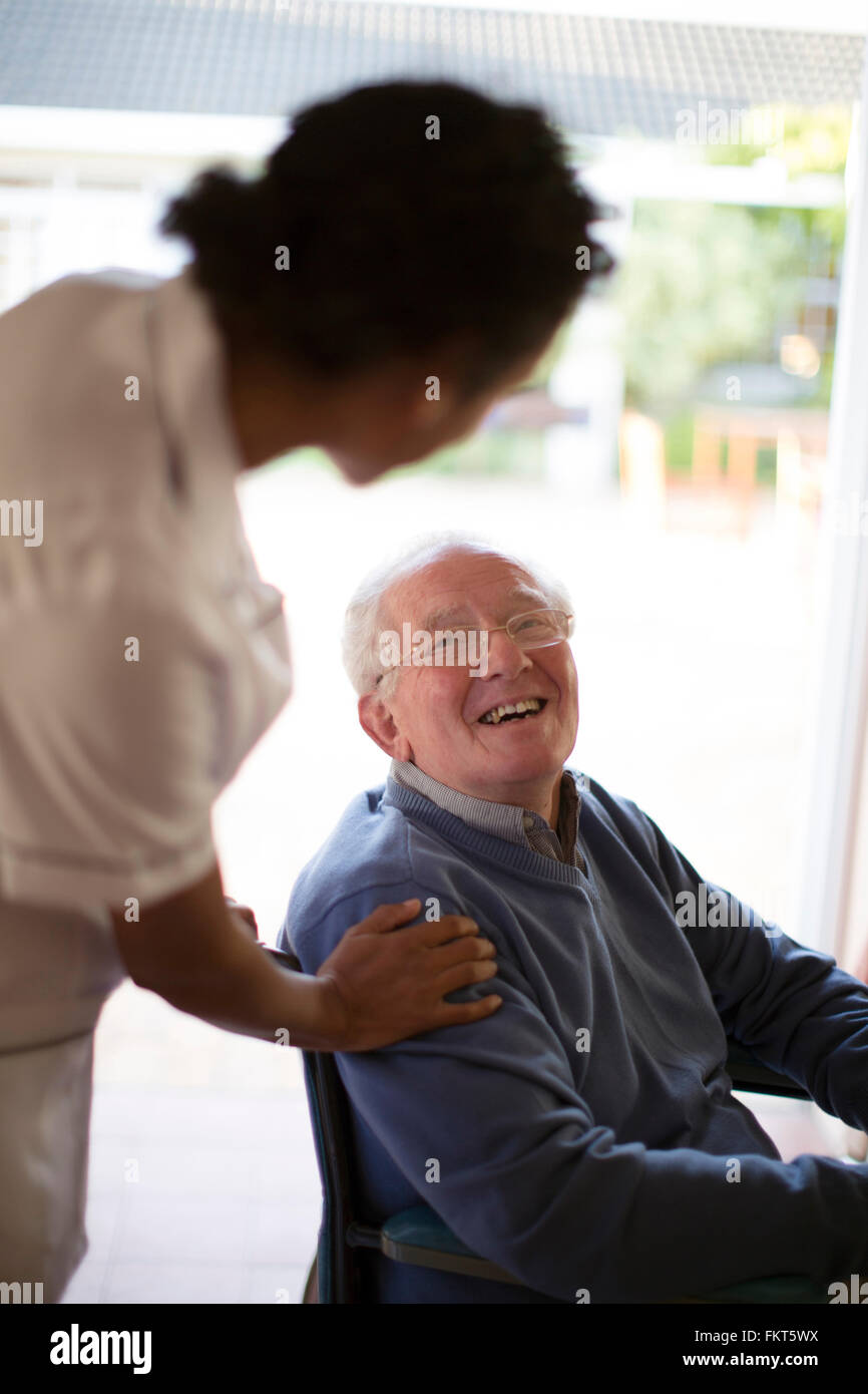 Medico di parlare al paziente in sedia a rotelle Foto Stock