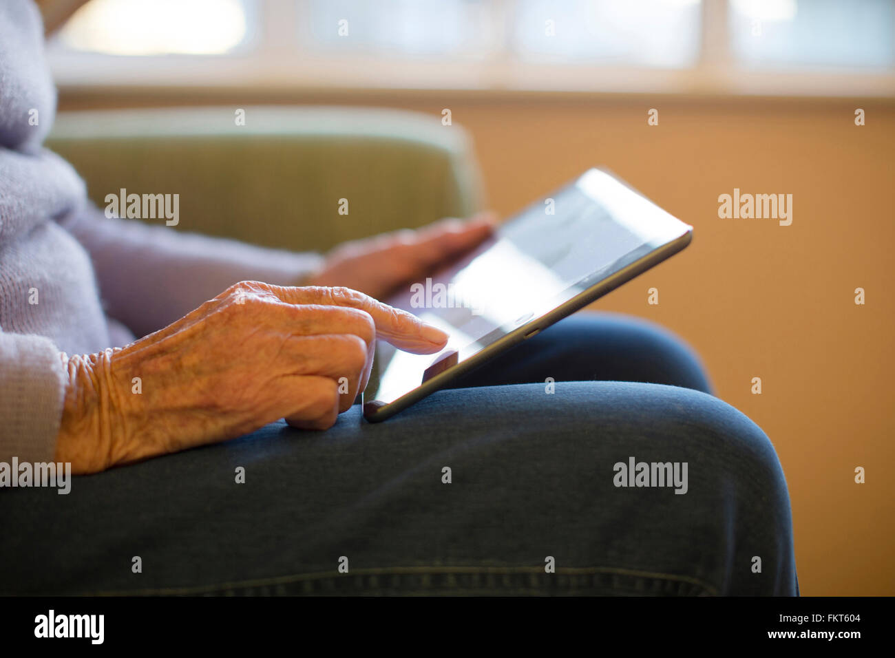 I vecchi donna caucasica utilizzando tavoletta digitale Foto Stock