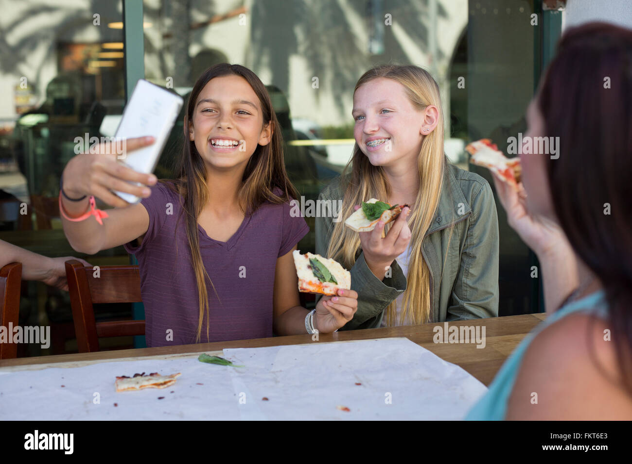 Le ragazze prendendo selfie in cafe Foto Stock