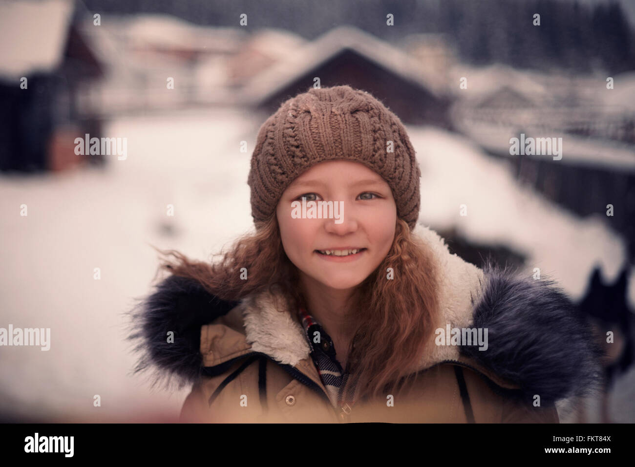 Ragazza caucasica indossando beanie hat e ricoprire nella neve Foto Stock