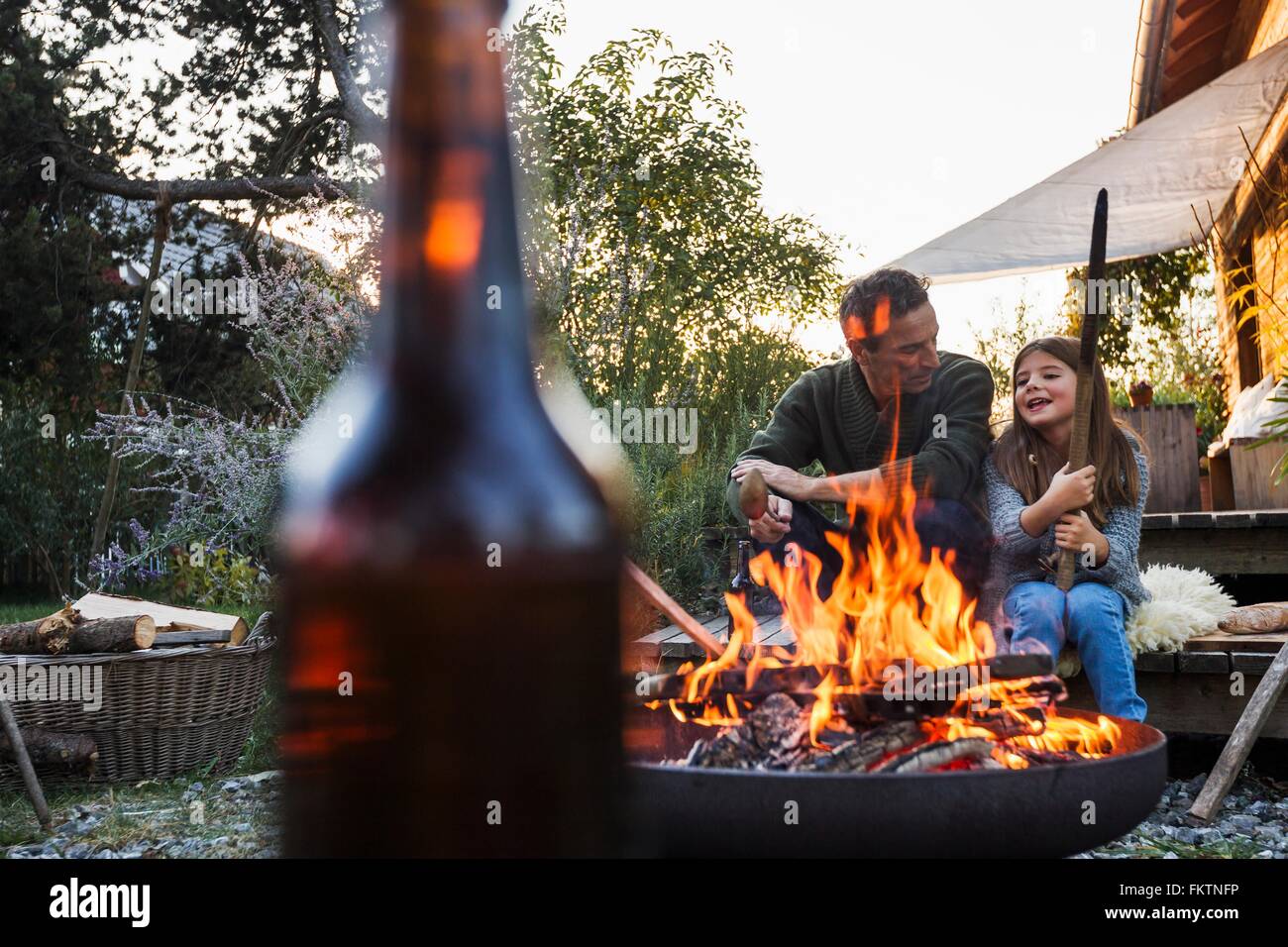 Padre e figlia in giardino con una buca per il fuoco Foto Stock