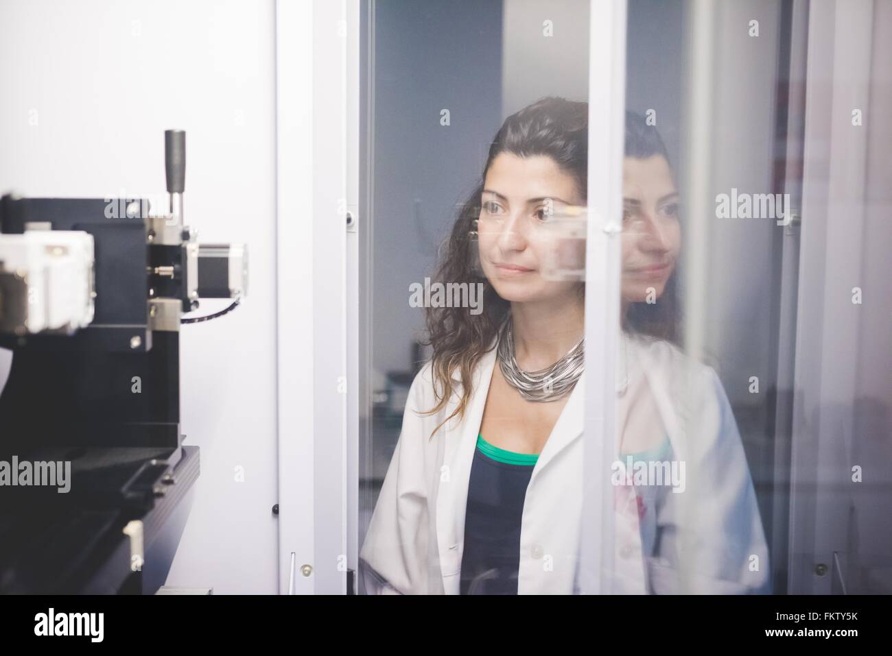 Donna scienziato monitoring allineamento del motore sul diffrattometro a raggi x la macchina Foto Stock
