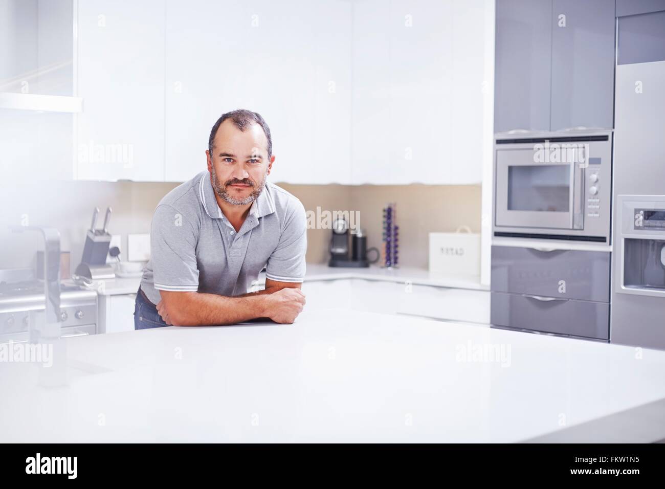 Ritratto uomo maturo appoggiata sul banco di cucina Foto Stock