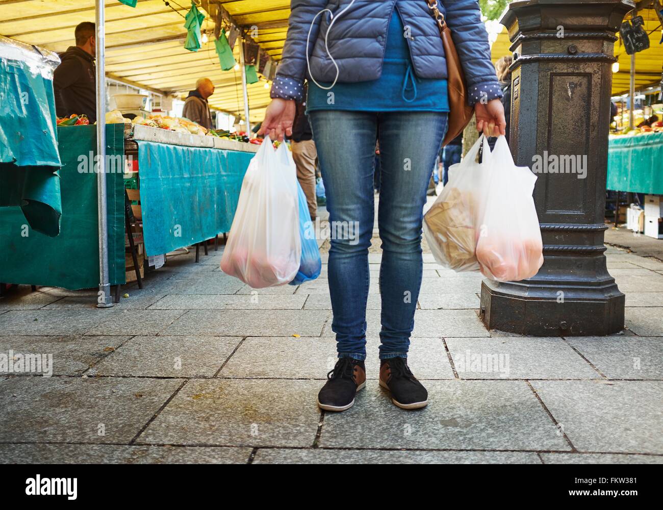 Giovane donna al mercato, sacchetti di contenimento di shopping, sezione bassa Foto Stock