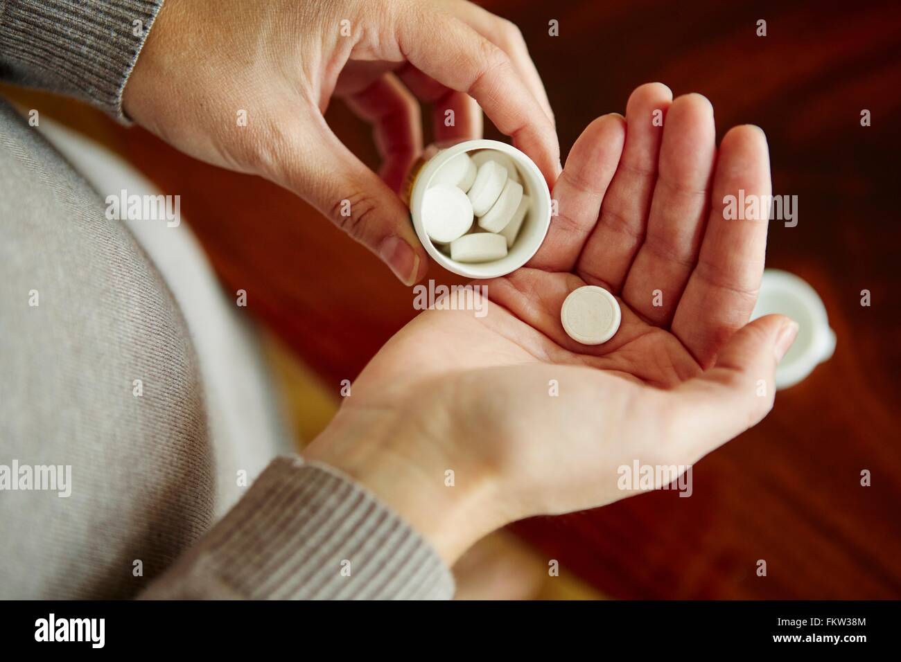 Giovane donna prendendo farmaci da vasca, close-up Foto Stock