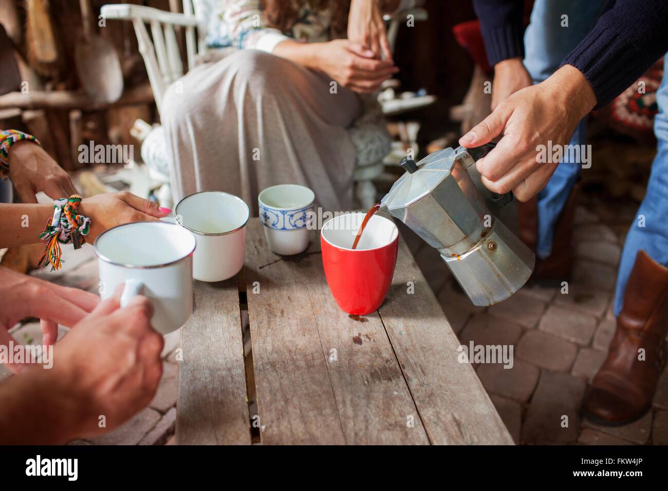 Ritagliato colpo di amici adulti versando il caffè in cabina Foto Stock